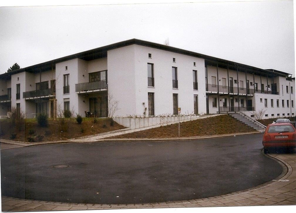 Dreigeschossiges weißes Wohngebäude mit Balkonen